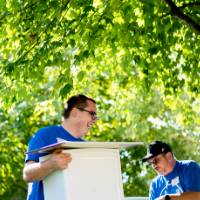 Alumni helping students move boxes into their dorm.
